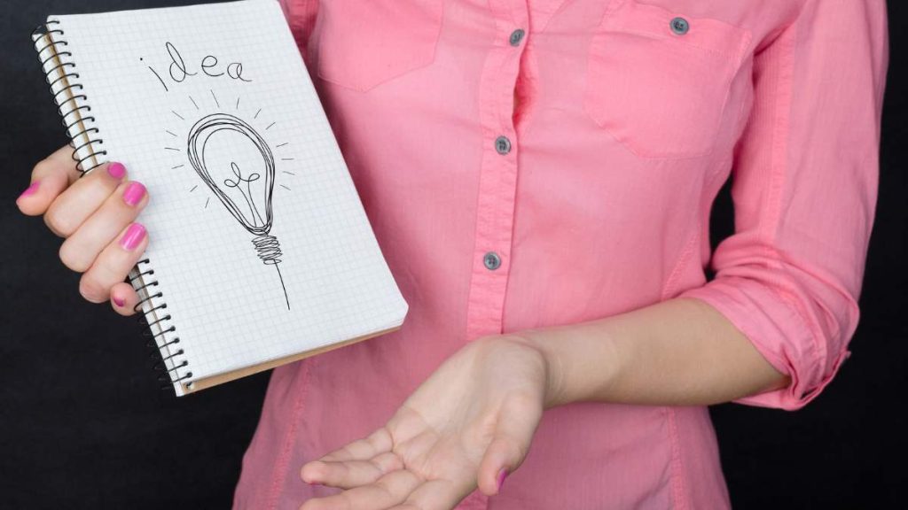 Girl holding notebook with tips word wearing pink